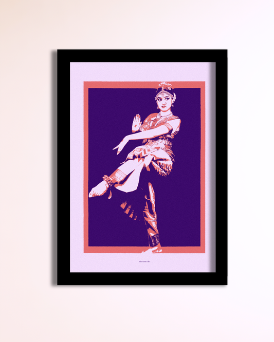 A framed art print featuring a stylized pop-art illustration of a bharatanatyam dancer in pink and white against a deep purple background, enclosed in a black frame and mounted on a light beige wall.