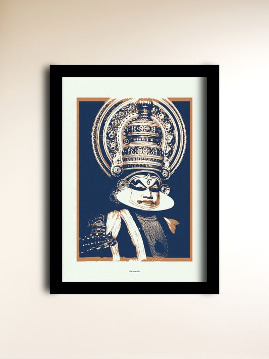A framed art print featuring a stylized illustration of Kathakali, shown against a dark blue background with cream and tan details. The print is mounted with a wide cream mat and enclosed in a slim black frame, hanging on a light beige wall.