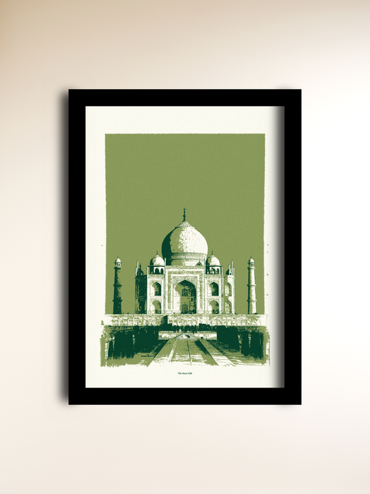 A framed art print of the Taj Mahal, featuring a green and white graphic illustration of the landmark with a black frame, displayed on a light beige wall.